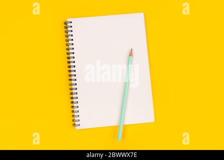 Leeren Notizbuch und Bleistift auf gelbem Hintergrund, Ansicht von oben. Stockfoto