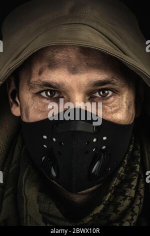 Dunkle Foto von Young Handsome Mann trägt schwarze protaktive Gesichtsmaske und Kapuze in der Straße der Nacht usa Stadt Stockfoto