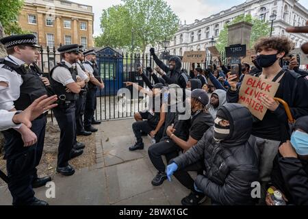 Black Lives Matter (BLM) Aktivisten und Unterstützer konfrontieren die Polizei in Westminster wütend fordern alle Offiziere ein Knie zu zeigen, Solidarität Unterstützung für die Black Lives Matter Bewegung nach dem Tod von George Floyd, ein schwarzer Mann, der in Polizeigewahrsam am 25. Mai in Minneapolis starb. London, Großbritannien. Stockfoto