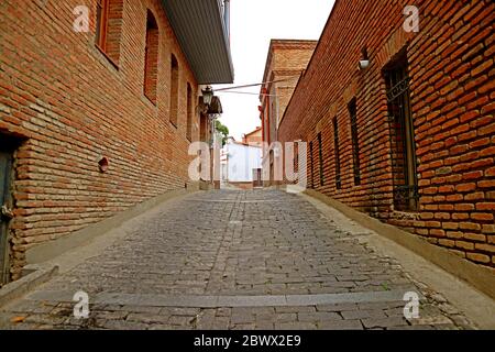 Schmale Gasse mit gemauerten Gebäuden in der Altstadt von Tiflis, Georgien Stockfoto