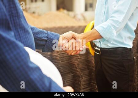 Ingenieurhände schütteln am Arbeitsplatz Gebäude Baugrundstück Projekterfolg, Geschäftsleute schütteln Hand Vereinbarung Investmentgeschäft Stockfoto