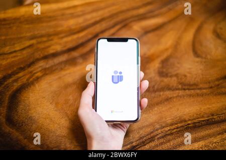 BANGKOK, THAILAND - 17. MAI 2020: Ein Benutzer öffnet die Microsoft Teams Anwendung auf dem Smartphone-Bildschirm auf dem Holztisch. Microsoft Teams ist ein beliebtes A Stockfoto