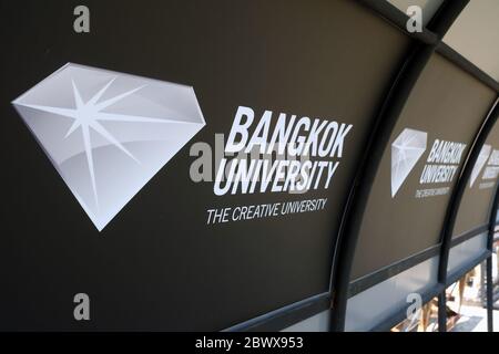 BANGKOK, THAILAND - 29. JANUAR 2020: Bangkok Universität Schild auf Rückenlehne der Soccer Bench Shelter. Bangkok Universität ist eine berühmte private Universität i Stockfoto