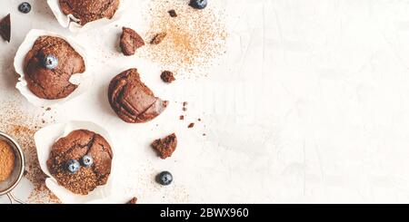 Hausgemachte, frische Schokoladenmuffins mit Beeren und Schokoladenstücken. Stockfoto