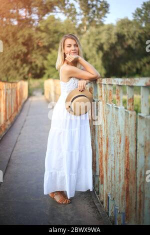 Frau in Hut und Sonnenbett für einen Spaziergang auf dem Land. Stockfoto