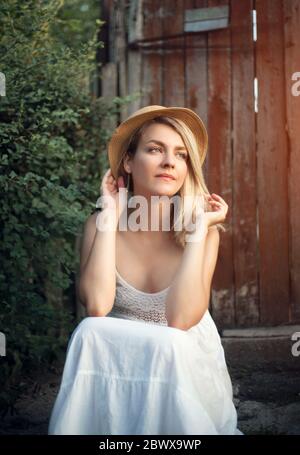 Frau in Hut und Sonnenbett für einen Spaziergang auf dem Land. Stockfoto