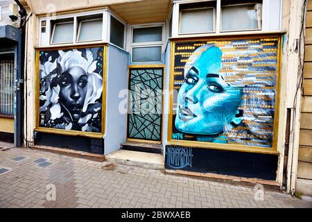 Bemalte Gesichter in Schaufenster in Bristol, Großbritannien, England Stockfoto