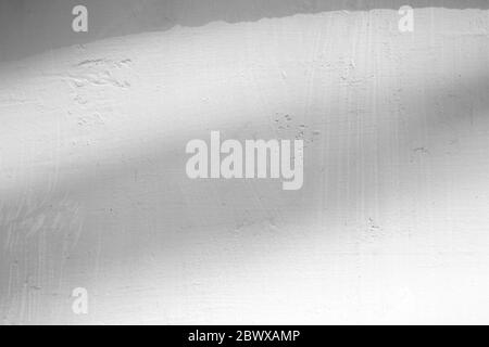 Lichtstrahl und Schatten auf weißem Beton Wandtextur Hintergrund, geeignet für Overlay, Produktpräsentation, Hintergrund und Mockup. Stockfoto