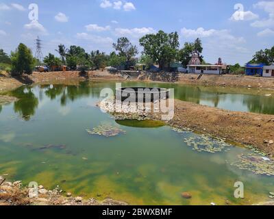 Dorfwasser gut auf Teich gelegen.der große Durchmesser Wasserbrunnen auf der Mitte des Tempels Teich in indischen Dorf. Stockfoto