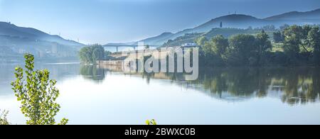 Moody-Aufnahme der Weinberge des Douro Valley und ironischer Sandeman erntete einen Mann namens Don, der in einem portugiesischen Studentenumhang auf einem Hügel mit Blick auf den Fluss gekleidet war Stockfoto