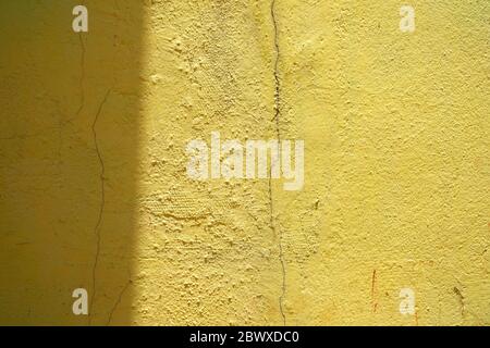 Sonnenlichtschranke auf Grunge Gelbe Farbe Betonwand Hintergrund. Stockfoto