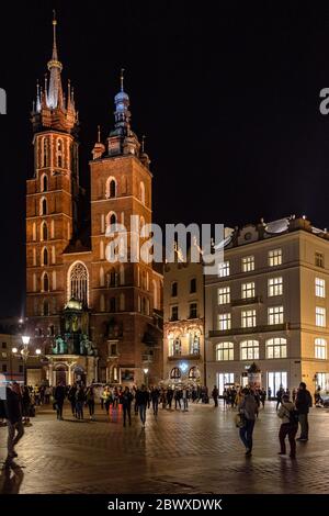 Die Marienkirche in Krakau in den Rynek Glowny Hauptplatz in der Altstadt bei Nacht mit Touristen Stockfoto