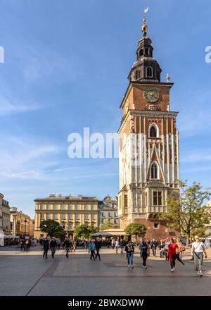 Der Rathausturm über Touristen auf dem Hauptplatz der Altstadt in Krakau, Polen an einem warmen Herbsttag Stockfoto