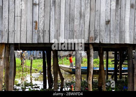 Afrika, Westafrika, Benin, Nokouesee, Ganvié. Ein Kind bringt sein Boot zum Anlegeplatz in der Seestadt Ganvié. Stockfoto