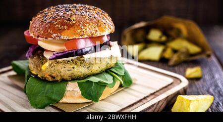 Vegetarischer Hamburger, Sandwich ohne Fleisch, mit Portion pommes Frites. Sandwich mit Pilzen, Tomaten, Salat, Rucola, Eiweiß und Pilzen Stockfoto