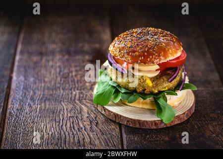 Veganer Hamburger, Sandwich ohne Fleisch, mit einem Glas grünen Saft im Hintergrund. Sandwich mit Pfeffer, Pilz, Tomaten, Salat und Eiweiß Stockfoto