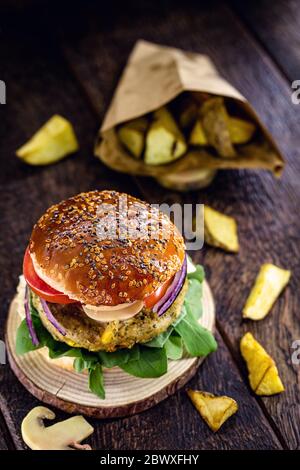 Vegetarischer Hamburger, Sandwich ohne Fleisch, mit Portion pommes Frites. Sandwich mit Pilzen, Tomaten, Salat, Rucola, Eiweiß und Pilzen Stockfoto