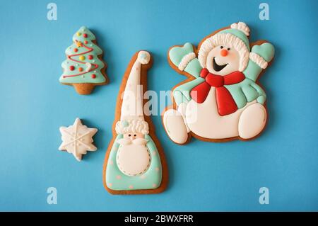 Lebkuchen Zucker glasierte Cookies Figuren Weihnachten niedliche Dekoration blau Papier Hintergrund Stockfoto
