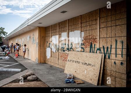 Minneapolis, Minnesota / USA - 2. Juni 2020: Freiwillige säubern Graffiti auf beschädigten und zerstörten Gebäuden mit eindringlichen Graffiti "Can you hear US now" Stockfoto