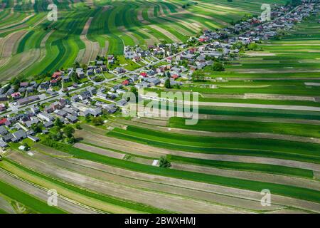 Polen von oben. Luftaufnahme von grünen landwirtschaftlichen Feldern und Dorf. Landschaft mit Feldern von Polen. Typische polnische Landschaft. Stockfoto