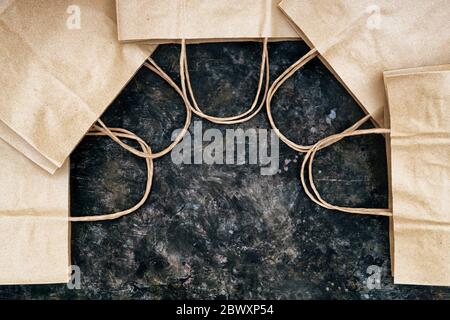 Nahaufnahme von leeren Papier Einkaufstaschen auf einem Grunge Hintergrund, die eine Hausform angeordnet. Kreatives Konzept für den Einkauf im Haushalt. Stockfoto