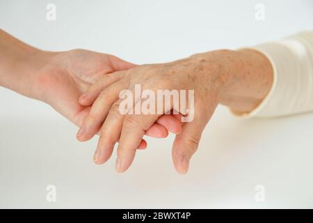 Helfende Hände, Pflege für ältere Menschen Konzept. Die Hand des Arztes hält die Hand einer Frau Stockfoto