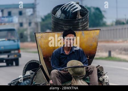 Ein Mann, der einen überlasteten Kleintransporter auf einer Autobahn in Vietnam fährt Stockfoto
