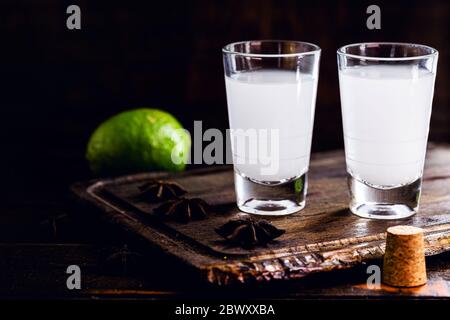 Ouzo oder Uzo, ist ein griechischer Anisbrand, ein traditionelles starkes alkoholisches Getränk in Gläsern auf dem alten Holztisch. Griechische Tradition, trinken der Götter. Ort Stockfoto