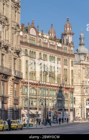 Budapest, Ungarn - 9. Feb 2020: Szabad Sajto Straßenansicht mit Parisi Udvar Hotel vor Sonnenuntergang Stockfoto