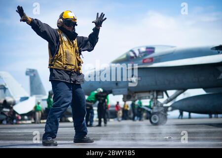 U.S. Navy Aviation Boatswain Mate 3. Klasse Dylan Allsopp leitet ein F/A-18E Super Hornet Jagdflugzeug, das den Sunlinern der Strike Fighter Squadron 81 auf dem Flugdeck des Nimitz-Klasse Flugzeugträgers USS Harry S. Truman zugewiesen wurde, 9. Mai 2020 im Atlantischen Ozean. Stockfoto