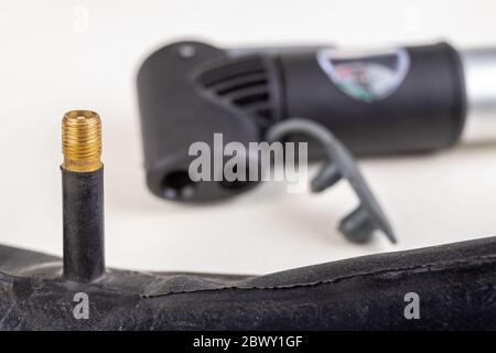 Gummi Fahrradschlauch und Pumpe. Fahrradzubehör für die Reparatur von Reifen. Heller Hintergrund. Stockfoto