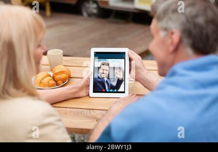 Ältere verheiratete Paar Kommunikation mit Sohn über Tablet-Computer auf dem Land Stockfoto