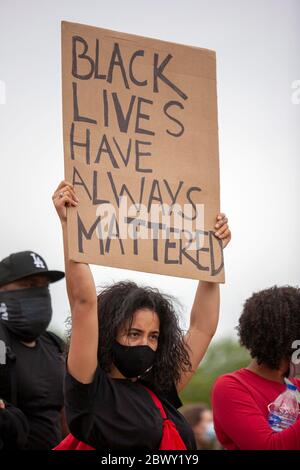 Junge Frau, die eine Gesichtsmaske trägt und ein Schild mit der Aufschrift "Schwarze Leben haben immer eine Rolle" hält, während des Protestes von Black Lives Matter UK. London Stockfoto