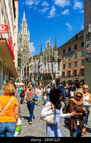 Menschenmassen versammeln sich auf dem Marienplatz in München, bevor es um die Mittagszeit zur täglichen Glockenspiel-Show geht Stockfoto