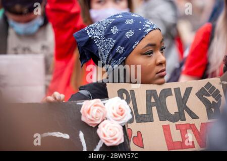 Junge Frau, die ein Kopftuch trug, setzte sich während des protestmarsches von Black Lives Matter in Großbritannien in eine Menschenmenge. London, England, Großbritannien Stockfoto