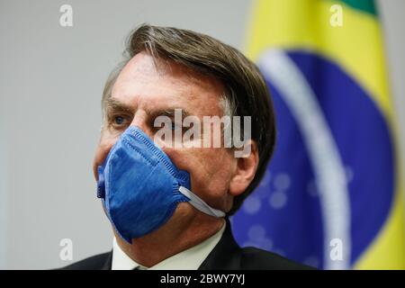 Der brasilianische Präsident Jair Bolsonaro trägt während einer Videokonferenz im Präsidentenpalast Planalto am 20. März 2020 in Brasilia, Brasilien, eine PPE-Maske inmitten der COVID-19-Pandemie. Stockfoto