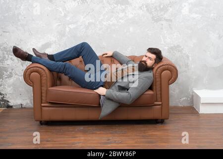 So sieht Vertrauen in den Menschen aus. Bärtiger Mann auf dem Sofa entspannen. Brutaler Mann in Business Casual. Modetrend. Modischer Stil. Unrasiert Mann mit Bart und Schnurrbart Haar. Barbershop. Friseursalon. Stockfoto