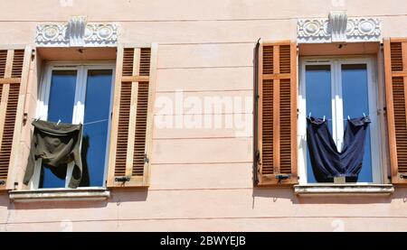 Hängende Kleidung und Fenster mit Fensterläden, Provence, Frankreich. Konzept aus dem echten Leben. Stockfoto