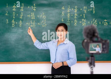 Asiatische Grundlehrer Tutor erklären Mathematik in Tafel geben Remote-Schule Klasse Online-Unterricht Unterricht Blick auf Kamera im Klassenzimmer von e-learni Stockfoto