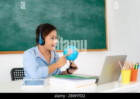 Asiatische Frau Lehrer Geographie über Videokonferenz E-Learning in Laptop mit Tafel im Klassenzimmer unterrichten. Homeschooling und Fernunterricht, auf Stockfoto