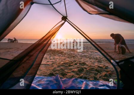 Blick durch die Tür öffnen von orange und grau Zelt Camping Sommer Strand Hintergrund am Morgen. Stockfoto