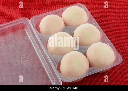 Gefrorenes Erdbeer Eis Mochi in Kunststoffverpackung auf gedeckten Tischdecken Stockfoto