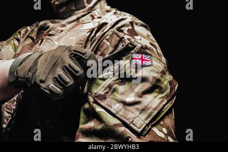 Foto eines britischen Soldaten in multicam Tarntunika mit Tasche auf schwarzem Hintergrund. Stockfoto