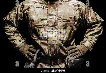 Foto eines Soldaten in multicam Tarntunika und taktischer Gürtel mit Taschen auf schwarzem Hintergrund. Stockfoto
