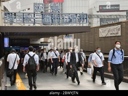 Morgen. Juni 2020. Büroangestellte tragen am 3. Juni 2020 in der Hauptverkehrszeit in Osaka, Japan, Gesichtsmasken am Bahnhof Osaka. Stockfoto