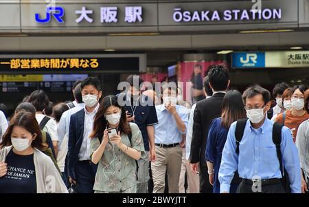 Morgen. Juni 2020. Büroangestellte tragen am 3. Juni 2020 in der Hauptverkehrszeit in Osaka, Japan, Gesichtsmasken am Bahnhof Osaka. Stockfoto