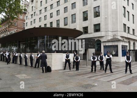 London, Großbritannien. Juni 2020. Polizeibeamte stehen Wache vor dem New Scotland Yard, während Protestierende an einer Demonstration in London, Großbritannien, am 3. Juni 2020 teilnehmen. Tausende von Menschen versammelten sich am Mittwoch in London, um gegen den Tod von George Floyd zu protestieren, einem unbewaffneten schwarzen Mann, der letzte Woche von einem weißen Polizisten im mittleren Westen des US-Bundesstaates Minnesota erstickt wurde. Kredit: Ray Tang/Xinhua/Alamy Live News Stockfoto