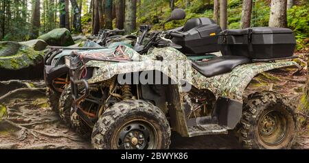 Foto von einem getarnten Jagd Offroad atv Fahrzeuge stehen in Wald Profil Ansicht. Stockfoto