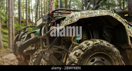 Foto von einem getarnten Jagd Offroad atv Fahrzeuge stehen in Waldrad Nahaufnahme Profilansicht. Stockfoto