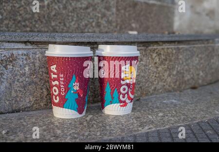 Zwei gebrauchte Costa Kaffeetassen mit weihnachtlichem Design auf einer Außentreppe. London Stockfoto